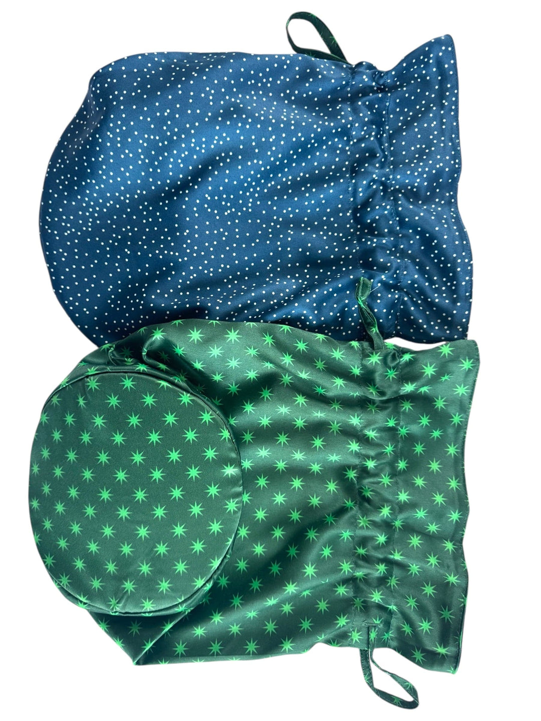 Two fabric bags, one blue with white polka dots and the other green with star patterns, on a white background.